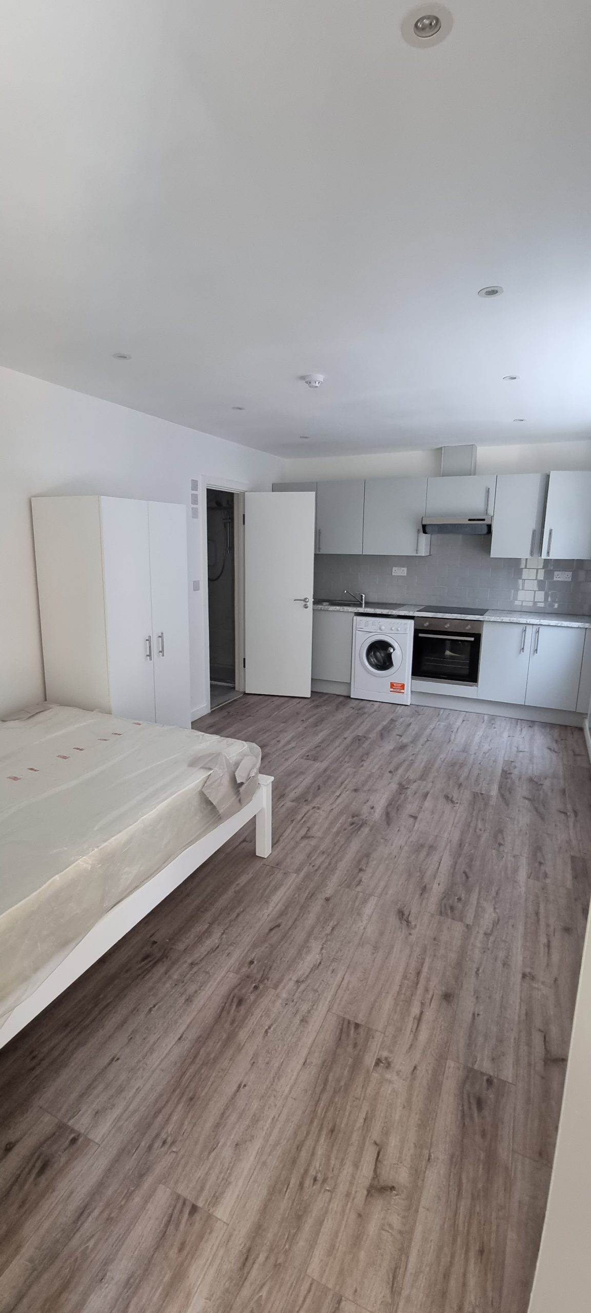 Finished flat interior showing the living area, kitchen and flooring